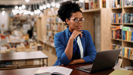 young woman working ata laptop in a library