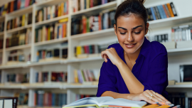 Girl reads a book in a library