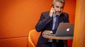 a businessman on his phone in front of a laptop